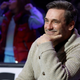 Jon. Hamm wears a tan cardigan sweater and smiles at an NHL All-Star Weekend event.